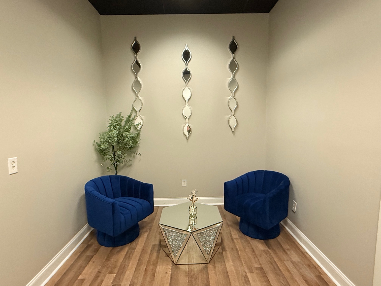 Sitting room with navy chairs and mirrors